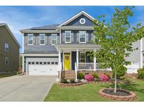 Charming two-story home with a welcoming porch, brick accents, and well-manicured lawn at 2308 Swansea Ln, Apex, NC 27502