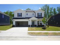 Inviting two-story home with a spacious driveway and a two car garage on a manicured front lawn at 3841 Rosebush Dr, Zebulon, NC 27597