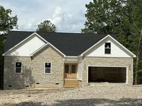 Stone and siding new construction home featuring a black roof and an attached two car garage at 42 Ponchartrain St, Fuquay Varina, NC 27526