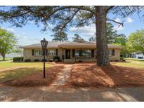 Charming single-story home with stone facade, mature landscaping, and inviting front porch at 609 W Main St, Benson, NC 27504