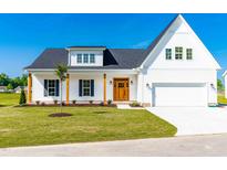 Charming two-story home with a well-manicured lawn, wood accents, and classic architectural details at 95 Watermeadow Dr, Clayton, NC 27520