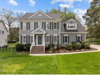 Charming gray home with manicured landscaping, brick steps and black shutters at 104 Dallavia Ct, Morrisville, NC 27560