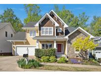 Charming two-story home featuring a stone facade, cedar shingles, and a well-manicured front yard at 109 Homegate Cir, Apex, NC 27502
