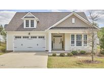 Charming home with a two-car garage, covered porch, and manicured lawn at 1112 Addington Lake Ln, Knightdale, NC 27545