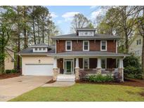 Charming two-story home with a welcoming front porch and well-maintained lawn surrounded by mature trees at 120 Cypress View Way, Apex, NC 27502