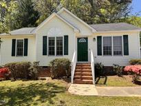 Charming home features green door and shutters, complemented by well-maintained landscaping at 1204 Amberstone Dr, Knightdale, NC 27545