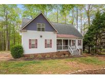 Charming two-story home featuring red shutters, covered porch and lush, mature landscaping at 147 W Alex Dr, Clayton, NC 27520