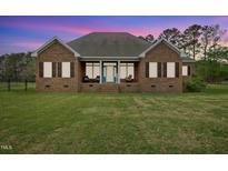 Inviting brick home featuring a cozy front porch and lush green lawn at 1500 Antioch Rd, Rocky Mount, NC 27801
