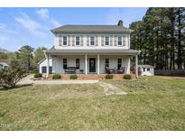 Traditional two-story home with a welcoming front porch and neatly maintained landscaping at 230 Bradley Dr, Benson, NC 27504