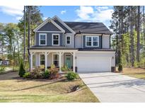 Charming two-story home featuring a covered front porch, two-car garage and manicured lawn at 254 W Odell Ln, Zebulon, NC 27597