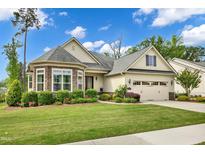 Charming home features a manicured lawn, beautiful landscaping, and an attached two-car garage at 2613 Beckwith Rd, Apex, NC 27523