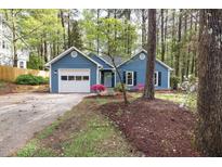 Charming blue home with an attached garage and well-manicured landscaping at 2709 Hidden Hollow Dr, Durham, NC 27703