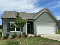 Charming one-story home featuring a two-car garage, manicured lawn, and tasteful landscaping at 288 Olivia Crossing Ct # 10, Four Oaks, NC 27524