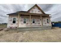New home under construction features a welcoming porch, windows, and durable construction materials on a spacious lot at 2895 Bakers Chapel Rd, Smithfield, NC 27577