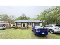 Charming single-story home with a well-maintained front lawn and multiple cars parked in front at 300 E Vance St, Zebulon, NC 27597