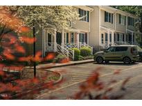 Inviting townhome exterior with parking, blooming trees, and cozy, covered front porches at 300 Nc 54 Highway # E2, Carrboro, NC 27510