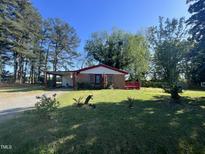 Charming single-story home with lush front yard and mature trees providing shade at 327 Holland Dr Rd, Smithfield, NC 27577