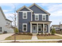 Charming two-story home with a covered front porch, blue siding, white trim, and well-maintained landscaping at 5712 Agrinio Way, Raleigh, NC 27603