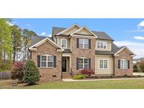 Beautiful two-story home with brick and siding, complemented by a well-manicured lawn and landscaping at 603 Goal Kick Dr, Fuquay Varina, NC 27526