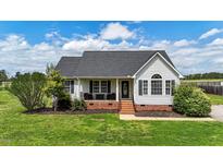 Charming single-story home featuring a welcoming front porch, well-manicured lawn, and inviting curb appeal at 82 Sommerset Dr, Clayton, NC 27520