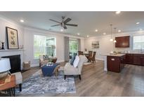 Bright living room features a fireplace, neutral paint, and hardwood floors at 108 Pronghorn Deer Ct, Garner, NC 27529