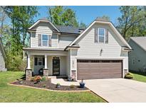 Charming two-story home featuring manicured lawn, well-kept flowerbeds, and a two-car garage at 1211 Yellow Wood Dr, Mebane, NC 27302