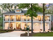 Stately two-story home featuring a double porch, a two-car garage, and mature landscaping at 1213 Rocky Point Ln, Durham, NC 27712