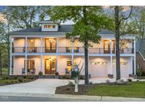 Stunning two-story home featuring a charming wrap-around porch, perfect for relaxing and enjoying the outdoors at 1213 Rocky Point Ln, Durham, NC 27712