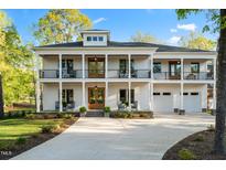 A beautiful, two-story home with a classic design, charming balconies, and a well-manicured lawn at 1213 Rocky Point Ln, Durham, NC 27712