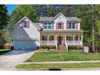 Charming two-story home with a covered front porch, red shutters, and a well-manicured lawn at 1310 Country Club Dr, Durham, NC 27712