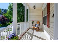 Inviting front porch with white railings and a rocking chair, perfect for relaxing outdoors at 1310 Country Club Dr, Durham, NC 27712