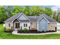 Beautiful single-story home featuring brick, light-blue siding, and a landscaped yard at 1325 George Bason Rd, Graham, NC 27253