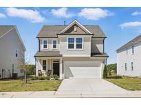 Charming two-story home featuring a two-car garage, covered entry, and well-maintained landscaping at 135 Carlton Ln, Franklinton, NC 27525