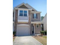 Two-story home featuring a stone facade, balcony, garage, and neutral siding at 157 Durants Neck Ln, Morrisville, NC 27560