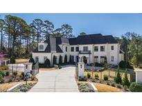 Stately white brick home featuring a gated entrance, manicured landscaping, and a circular driveway at 1601 Estate Valley Ln, Raleigh, NC 27613