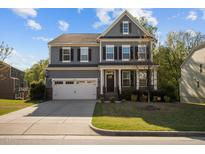 Charming two-story home with a well-manicured lawn, two-car garage, and inviting front porch at 1840 Flint Valley Ln, Apex, NC 27502