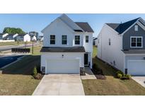 Charming white two-story home with a two-car garage and well-maintained landscaping at 205 Fig Tree Bnd, Zebulon, NC 27597