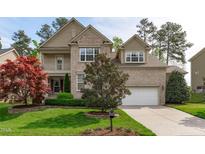 Charming two-story brick home featuring a well-manicured lawn and attached two-car garage at 2109 Hemlock Hill Dr, Durham, NC 27703