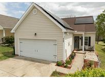 Charming home featuring a two-car garage, solar panels, and a welcoming front entrance at 2124 Castle Pines Dr, Raleigh, NC 27604