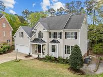 Charming two-story home with a manicured lawn, black shutters, and a covered porch at 213 Lewiston Ct, Cary, NC 27513