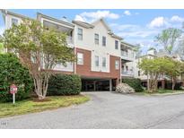 Attractive condo building with brick facade, upper balconies, and covered parking underneath at 2651 Mellow Field Dr # 206, Raleigh, NC 27604