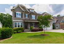 Charming two-story home featuring stone accents, shuttered windows, and a beautifully landscaped front yard at 2905 Pluton Pl, Rolesville, NC 27571