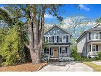 Charming two-story home with a welcoming porch and a bright yellow front door at 3 Maple St, Raleigh, NC 27610