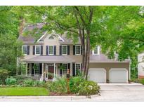 Charming two-story home with a welcoming front porch, mature trees, and a two-car garage at 307 Parkmeadow Dr, Cary, NC 27519