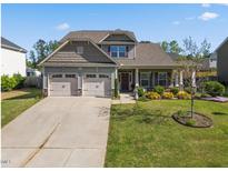 Charming two-story home featuring a well-maintained lawn, a two-car garage, and tasteful landscaping at 405 Club Center Dr, Youngsville, NC 27596