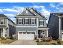 Charming two-story home with blue siding, stone accents, and a two-car garage in a well-kept neighborhood at 4905 Abundance Ave, Raleigh, NC 27616