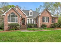 Charming brick home featuring a well-manicured lawn and inviting front entrance at 5900 Orchid Valley Rd, Raleigh, NC 27613