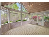 A beautifully screened porch with a vaulted ceiling provides serene views of lush trees at 5900 Orchid Valley Rd, Raleigh, NC 27613
