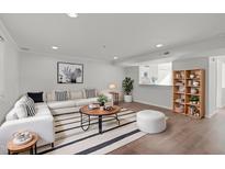 Bright living room features stylish sectional sofa, modern décor, and hardwood flooring at 7715 Bernadette Ln, Raleigh, NC 27615