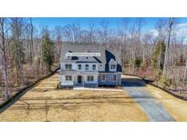 New construction home with stone accents and covered entry surrounded by wooded acreage at 0006 Tallulah Loop Lane, Cedar Grove, NC 27231
